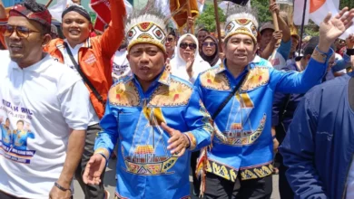 Jayapura — Pasangan bakal calon Wali Kota dan Wakil Wali Kota Jayapura, Jhony Banua Rouw dan H. Muhammad Darwis Massi (JBR-HADIR), resmi menjadi pasangan pertama yang mendaftarkan diri di Kantor Komisi Pemilihan Umum (KPU) Kota Jayapura pada Kamis siang (29/8/2024). JBR-HADIR memilih berjalan kaki dari kediaman Jhony Banua Rouw di Tanah Hitam menuju Kantor KPU Kota Jayapura. Mereka didampingi oleh Tim Koalisi, pimpinan partai pendukung (NasDem, PKS, Hanura, PSI, dan Gelora), relawan, simpatisan, serta perwakilan paguyuban lintas Nusantara dan tokoh adat. Ratusan pendukung setia ikut serta dalam perjalanan sepanjang hampir 1 kilometer tersebut. Sepanjang jalan, suasana terasa meriah dengan nyanyian, kibaran bendera partai, serta yel-yel “JBR-HADIR for Kota Jayapura” yang terus bergema. Rombongan tiba di Kantor KPU Kota Jayapura tepat pukul 11.25 WIT, disambut oleh Sekretaris KPU Kota Jayapura, Agusta Maniagasi, yang memberikan pengalungan sal batik bermotif Port Numbay kepada pasangan calon. Selanjutnya, Jhony Banua Rouw dan H. Muhammad Darwis Massi diterima oleh Ketua KPU Kota Jayapura beserta komisioner lainnya, serta anggota Bawaslu. Ketua Koalisi Perubahan JBR-HADIR, Otniel Deda, menjelaskan bahwa koalisi partai pengusung pasangan ini memiliki 14 kursi, yang cukup untuk memenuhi persyaratan pencalonan. Ia juga mengapresiasi dukungan dari berbagai elemen masyarakat yang turut serta. “Dukungan yang luar biasa ini menunjukkan semangat Bhinneka Tunggal Ika dalam pasangan JBR-HADIR,” kata Deda. HM Darwis Massi, yang merupakan calon Wakil Wali Kota, juga menyampaikan rasa terima kasihnya atas dukungan penuh dari masyarakat. “Mohon doa dan dukungannya mulai hari ini sampai 27 November 2024. Kami akan bekerja keras dan memberikan yang terbaik,” ujarnya penuh semangat. Sementara itu, Jhony Banua Rouw, calon Wali Kota, memaparkan visi dan misi pasangan JBR-HADIR, yakni mewujudkan "Kota Jayapura yang cerdas, aman, damai, dan sejahtera." Rouw menegaskan bahwa jika terpilih, mereka akan fokus pada peningkatan kualitas pendidikan, pelayanan kesehatan, dan penciptaan lapangan kerja baru bagi masyarakat Kota Jayapura. “Kami hadir untuk menjawab kebutuhan masyarakat, dan itulah yang akan menjadi prioritas utama kami,” tegas Rouw, yang bersama Darwis Massi saat ini juga menjabat sebagai anggota DPR Papua.